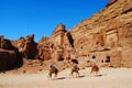 Tourists passing the Uneishu Tomb on the Street of Facades in Petra, Jordan Royalty Free Stock Photo